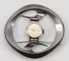 A ladies stainless steel manual wind watch, mounted in an abstract brooch, 52 x 48mm overall,