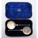 A silver pair of serving spoons, London 1911, crested, 19cm, 99gm, cased
