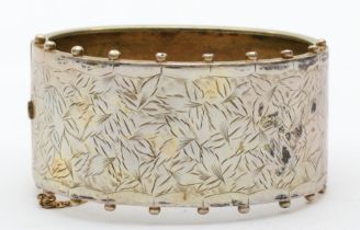 An early 20th century silver cuff bangle with foliate chased decoration, 54mm, 23gm.