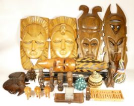 A box of 20th century carved wooden African wall masks, together with other ethnic and tribal items.