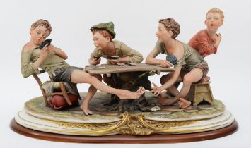 A 20th century Capodimonte porcelain figure, The Cheats, modelled by B.Merli, raised on an oval