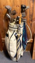 A selection of vintage and modern golf clubs with golf bag.