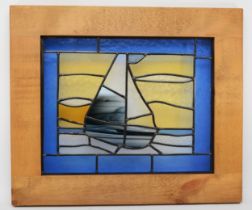A framed stained glass panel depicting a sailing boat, 44.5 x 56cm.