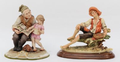 Two 20th century Capodimonte painted porcelain figures, man and girl reading wit dog and their feet,