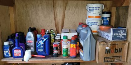 A shelf of unused motor oils and fluids to include two 5L 5W-30 engine oil bottles, Mobil break