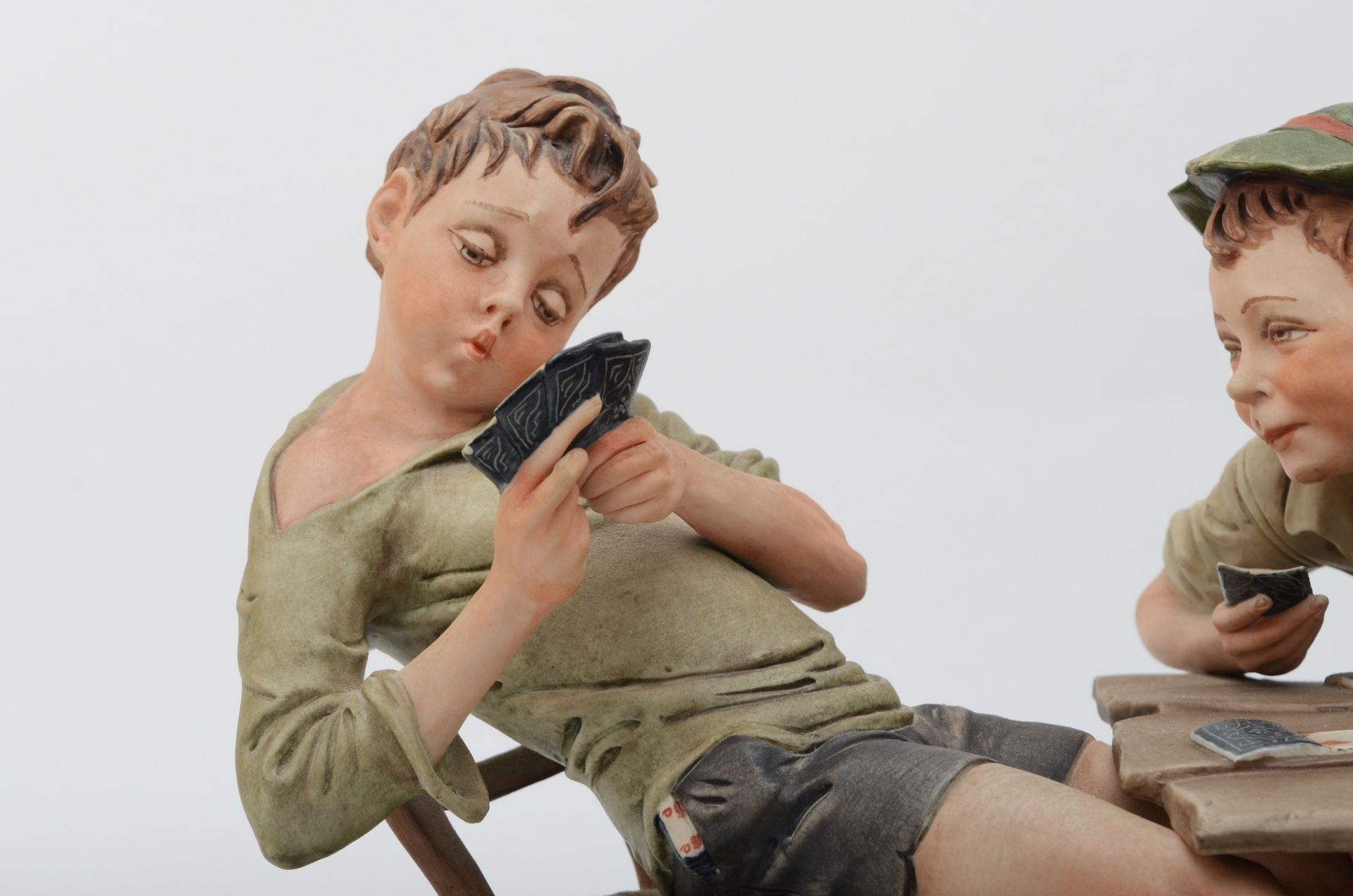 A 20th century Capodimonte porcelain figure, The Cheats, modelled by B.Merli, raised on an oval - Image 2 of 6