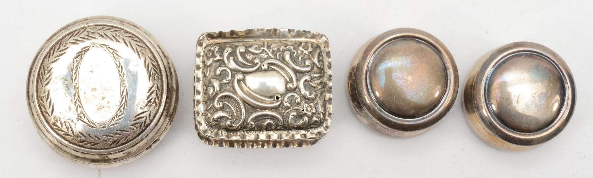 Four silver pill boxes to include a Victorian embossed foliate scroll example, London 1898, 4 x 3. - Image 2 of 3