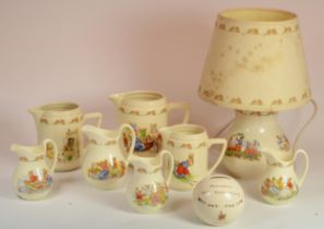 Royal Doulton Bunnykins; a Bunnykins to the Station lamp base, together with seven jugs and a 60th