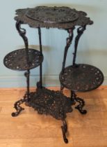 A Coalbrookdale style green painted cast iron four level stand, raised on pierced scroll supports,