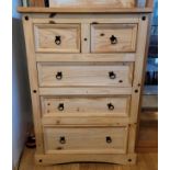 A contemporary stripped pine chest of two over three long drawers, raised on shaped bracket feet,