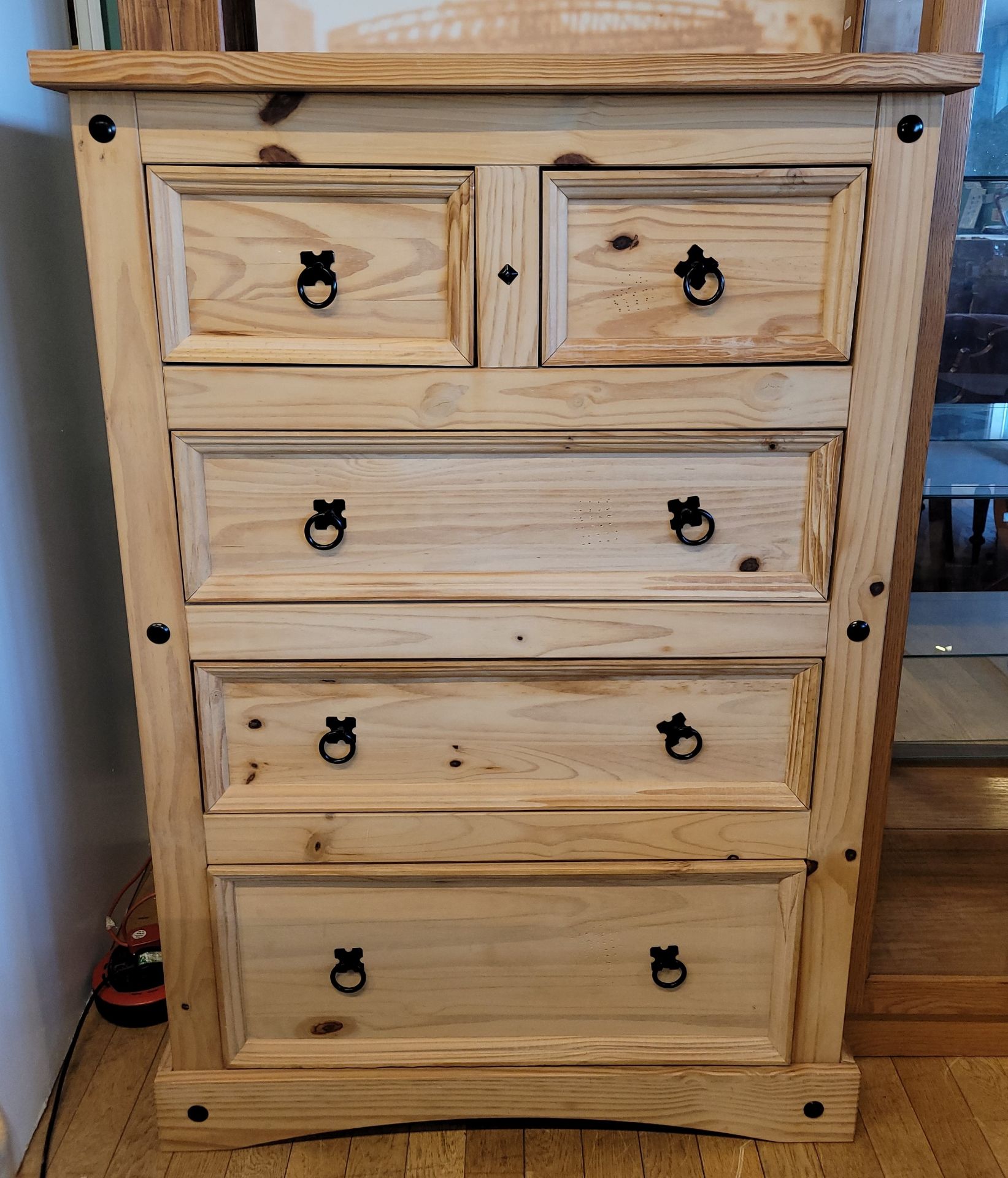 A contemporary stripped pine chest of two over three long drawers, raised on shaped bracket feet,