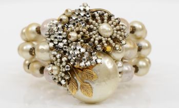 A Miriam Haskell three strand faux baroque pearl and foil backed rhinestone floral bracelet, c.1950,