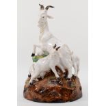 A richly painted and glazed porcelain figural group of four goats raised on naturalistic base,