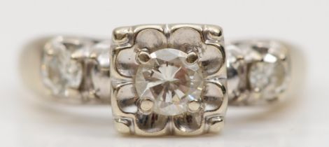 A 14k white gold brilliant cut diamond ring, with two brilliant cut diamonds set to the shoulders,