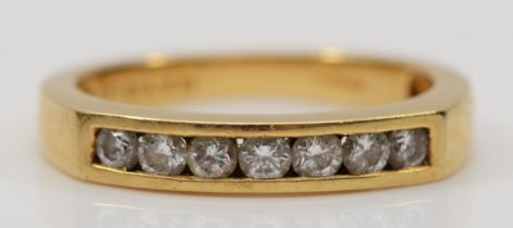 An 18ct gold brilliant cut channel set diamond half eternity ring, M, 3.4gm.