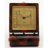 Jaeger, an Art Deco brass tortoiseshell effect folding travelling alarm clock, the dial with