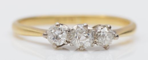 An 18ct gold three stone diamond ring, claw set with two old cut brilliant and one brilliant cut