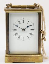 A 20th century brass corniche cased half hourly striking carriage clock, the white dial with black