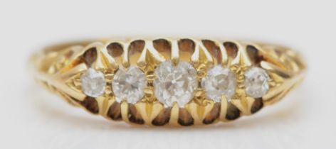 An Edwardian 18ct gold and old cut brilliant diamond five stone ring, carved shoulders, N, 3.3gm