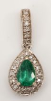 An 18k white gold pear cut emerald and diamond pendant, 22 x 9mm, 1.8gm.