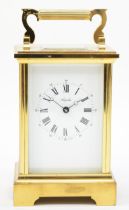 An English brass corniche cased striking carriage clock, the white dial with black Roman and