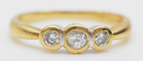 An 18ct gold three stone brilliant cut diamond ring, collet set stone, M, 3gm