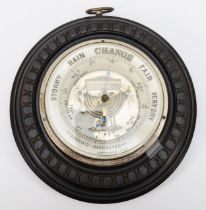 A late 19th/early 20th century ebonised cased circular aneroid barometer, the white dial retailed by