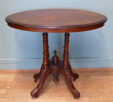 A small Victorian mahogany oval table with floral inlay, on a carved quadripartite birdcage base