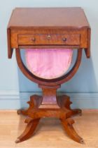 An oak drop leaf sewing table, with two sets of drawers, raised on invert bow stretcher, standing on