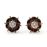A pair of unmarked gold brilliant cut diamond single stone floral stud earrings, stamped 9ct to