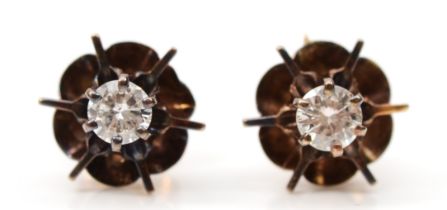 A pair of unmarked gold brilliant cut diamond single stone floral stud earrings, stamped 9ct to