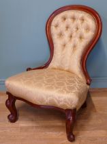 A 19th century mahogany framed button spoon back low nursing chair, raised on carved cabriole