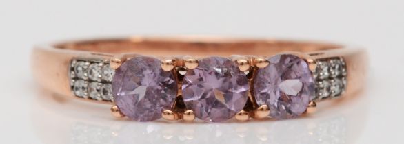 A 9ct rose gold three stone amethyst and white stone dress ring, Q, 1.7gm.