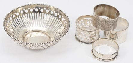 Four silver napkin rings to include a George V example, Chester 1911, together with a silver bon bon