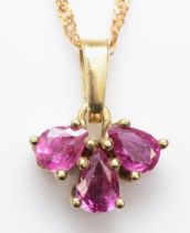 A 585 gold three stone pear cut ruby pendant, on 14k gold chain, 13mm, 2gm.