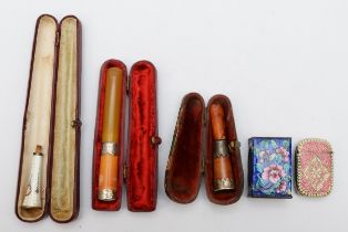 A group of cheroot holders to include a silver and enameled floral example, a silver enameled