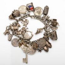 A silver charm bracelet with coins and charms, lacking clasp, 94gm.