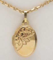 A 9ct gold oval locket with foliate scroll decoration, on 375 gold chain, 16 x 11mm, 5gm.