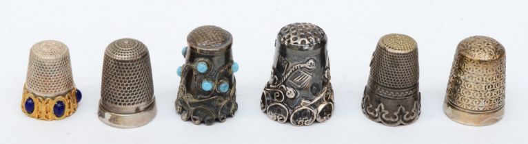 Six thimbles to include a silver example set with faux turquoise, and a continental silver floral