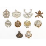 Ten military cap badges to include Royal Tank Regiment and Northamptonshire.
