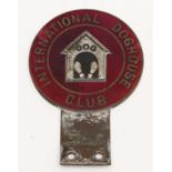 An International Doghouse Club car badge, c.1960, in red enamel with kennel design to the centre.
