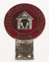 An International Doghouse Club car badge, c.1960, in red enamel with kennel design to the centre.