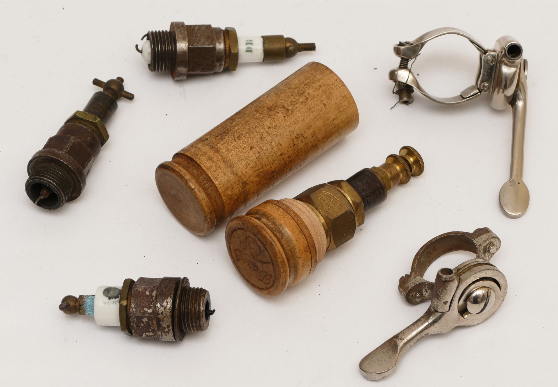 A veteran Darop brass spark plug, in wooden case, three other vintage spark plugs and and two levers