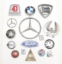 A collection of car badges, including Lancia and Fiat, together with a Ford 4D tractor badge