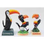 A cast iron and painted Guinness toucan, 19.5cm, and two smaller examples, 17cm (3).