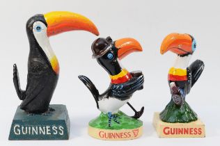 A cast iron and painted Guinness toucan, 19.5cm, and two smaller examples, 17cm (3).