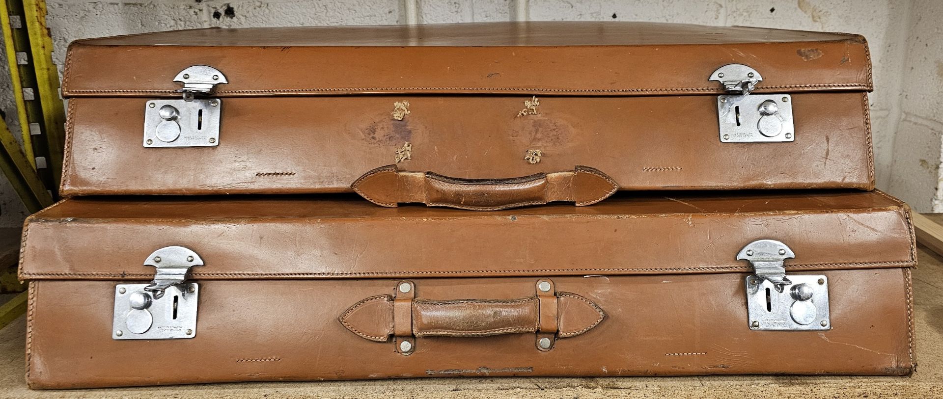 A two piece tan leather trunk set, 82 x 58 x 15cm and 82 x 48 x 15cm (2)