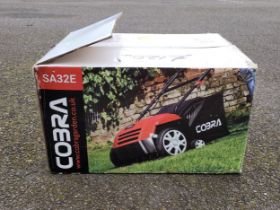 A Cobra SA32E 1400w 13" electric scarifier, unused in box.