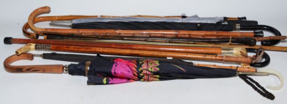 A collection of early 20th century and later walking sticks, canes, umbrella's and riding crops,