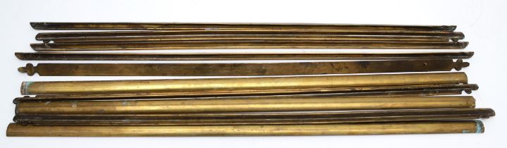 A set of seven brass fleur-de-lis shaped stair rods, 66cm long together with three dome shaped stair